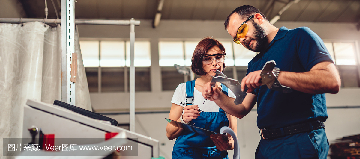 工廠主管在數控機床上測量切割出的產品