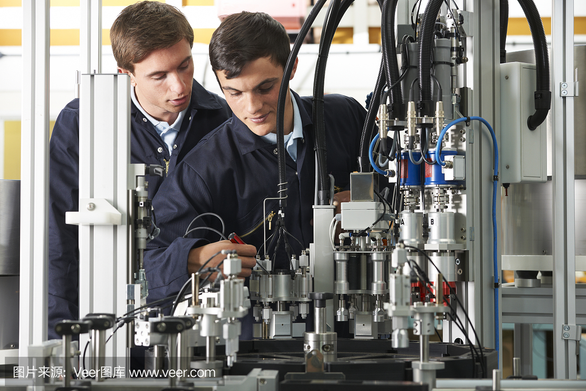在工廠設備上工作的工程師和實習生